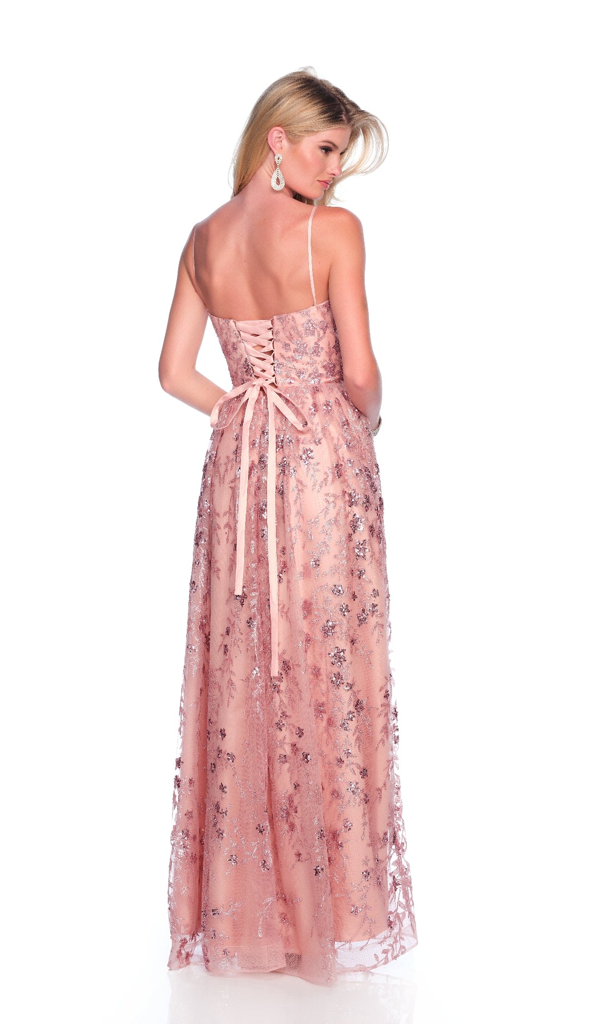 A woman faces away in the Dave & Johnny 11998 long pink prom dress, featuring delicate thin straps, a lace-up back, and embroidered 3D flowers, set against a plain white background.